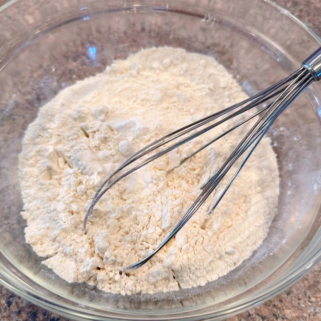 Mixing bowl with dry ingredients being whisked together.