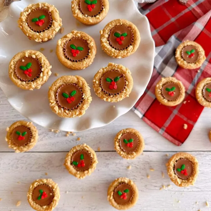 Overhead shot of Christmas Peanut Butter Cup Cookies on a white cake plate.
