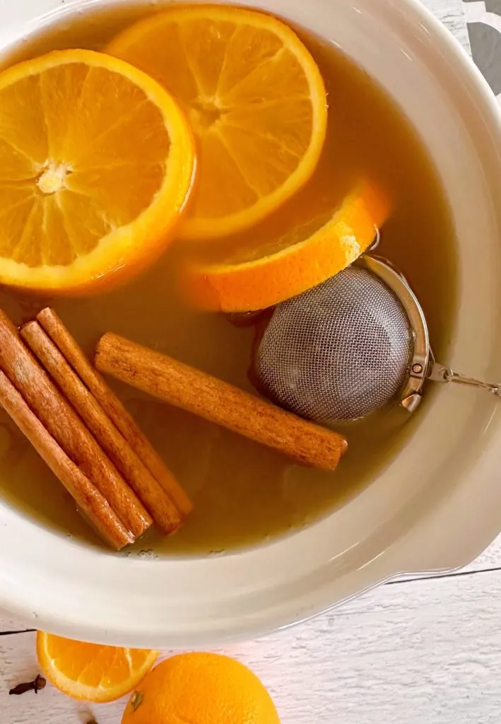 Adding Tea Ball with spices into Apple Cider.