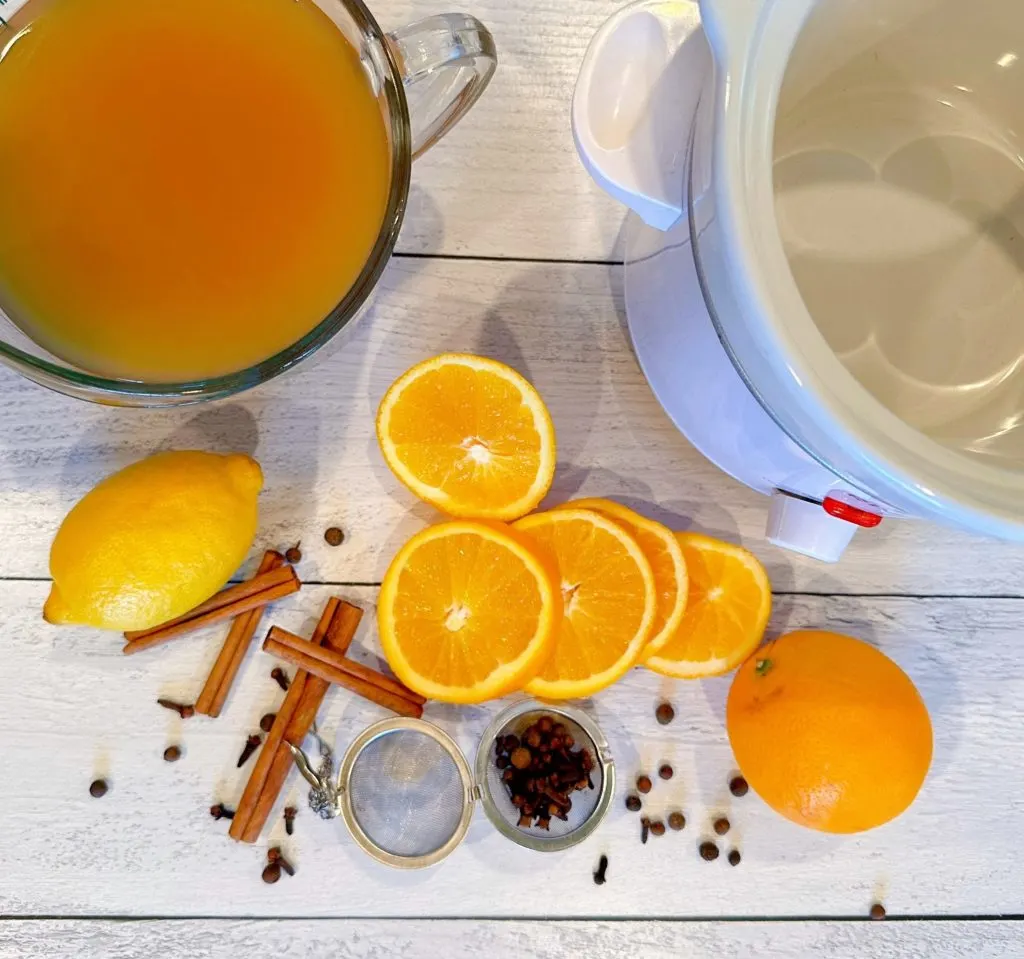 Ingredients for Old Fashioned Spiced Apple Cider on a wooden board.