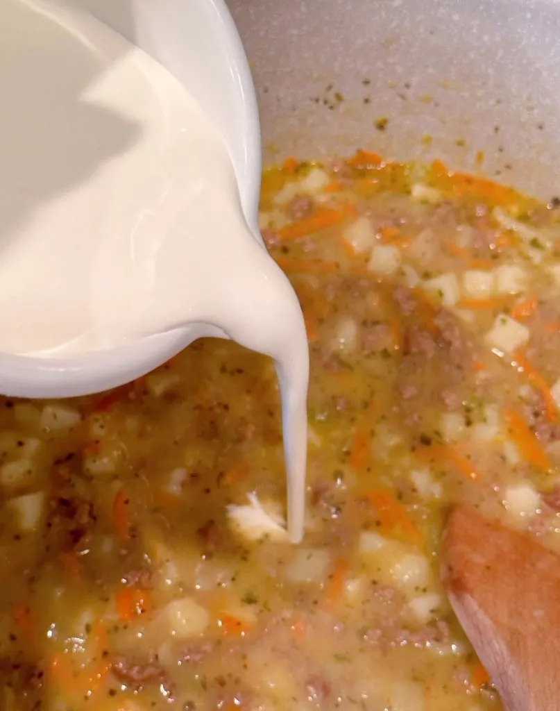 Adding heavy cream, salt and pepper to ground beef  mixture.