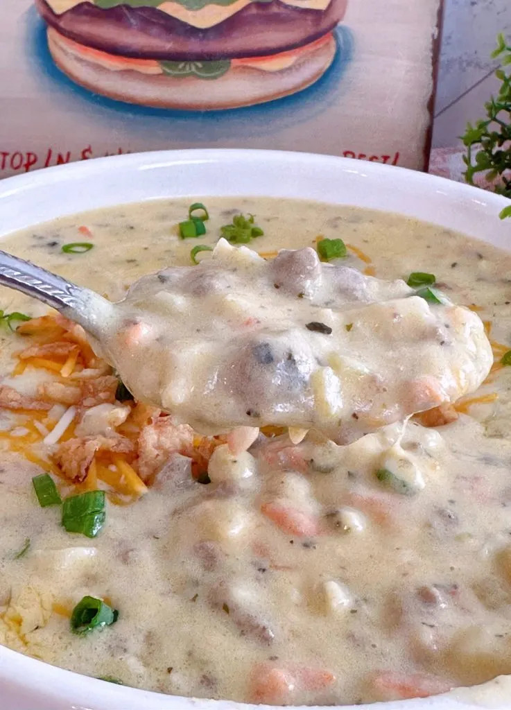 spoonful of cheeseburger soup over a bowl of the same.