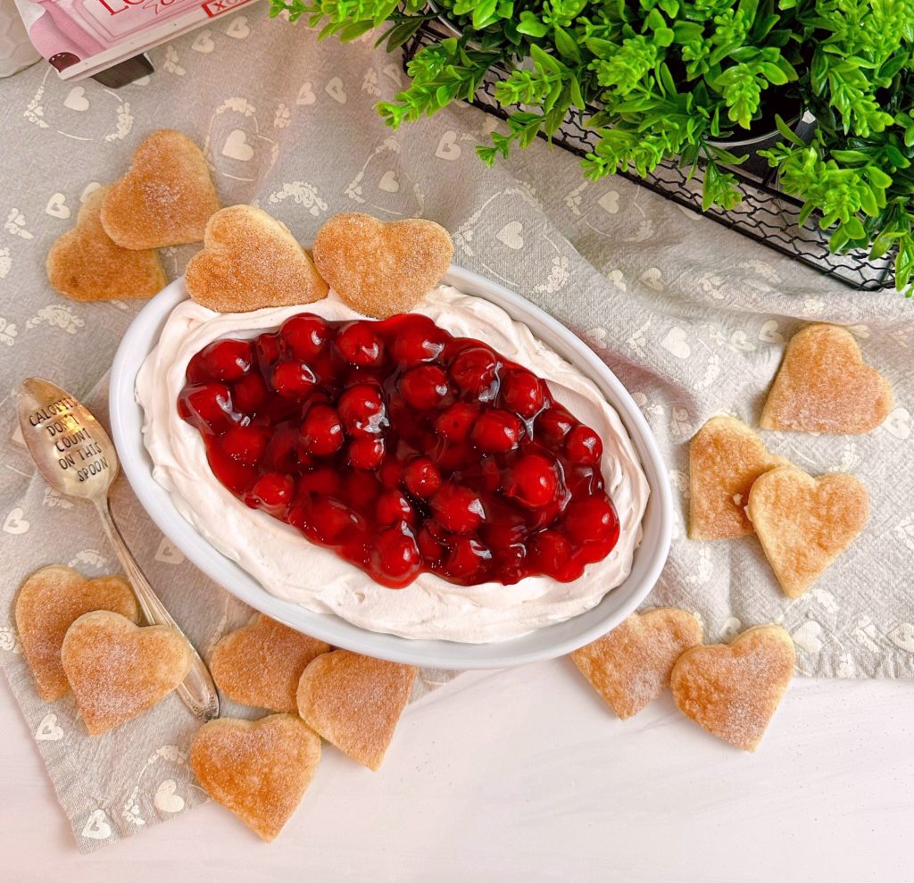 Overhead shot of Cherries on a cloud dip with pie crust hearts surrounding it.