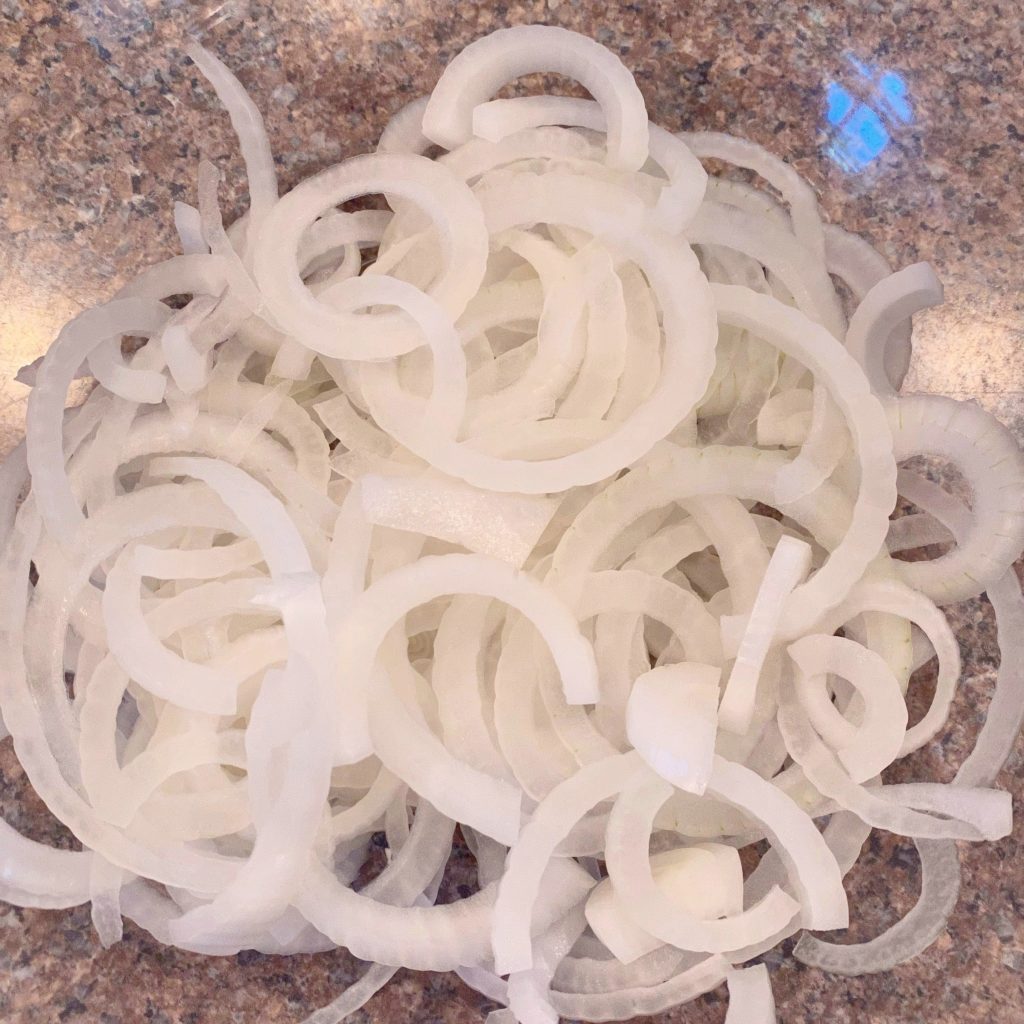 Onions sliced thinly and placed in a shallow bowl.