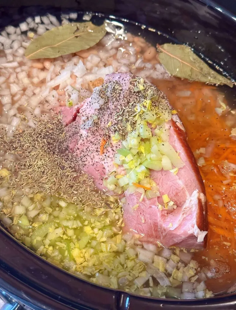Adding spices, seasonings, and chicken bouillon to ham soup.
