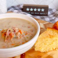 Navy Bean Soup in a white bowl with a slice of cornbread.