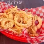 Crispy Onion Straws in a red burger basket with checkered paper.