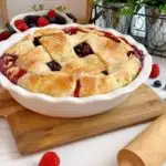 Triple Berry Deep Dish Galette on a cutting board with a rolling pin.