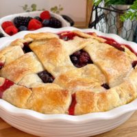 Triple Berry Deep Dish Galette up close with fresh berries in a basket in the background.