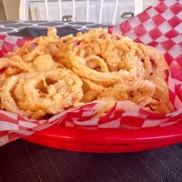 Easy Onion Strings in a red burger basket with checkered paper.