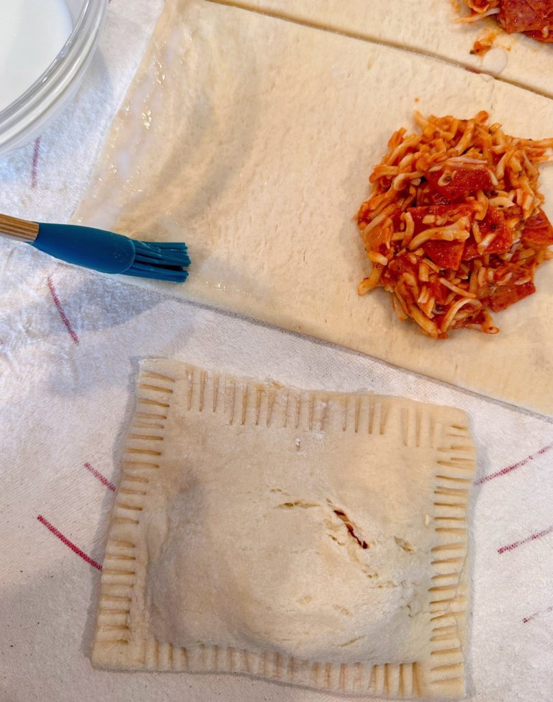 Brushing the inside of each calzone. 