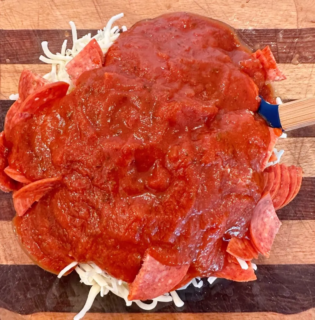 Adding sauce to pepperoni filling.