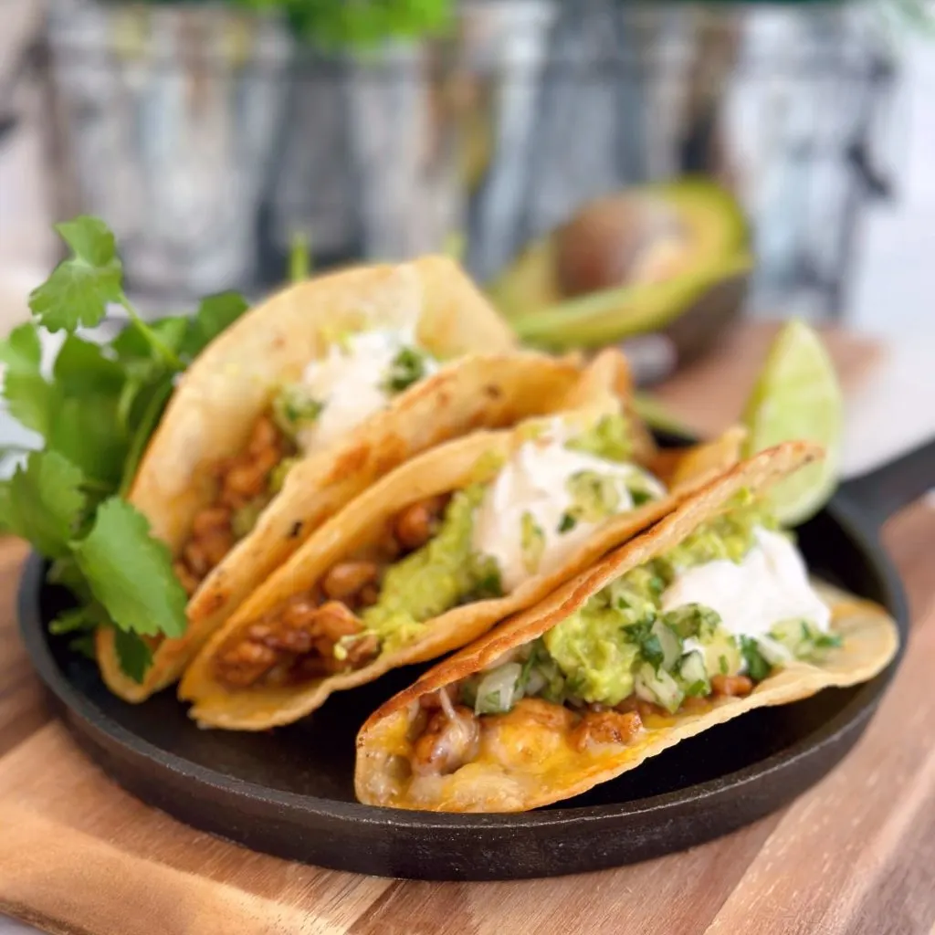 The Best Easy Chicken Skillet Tacos filled with guacamole, sour cream, cheese and flavored chicken.