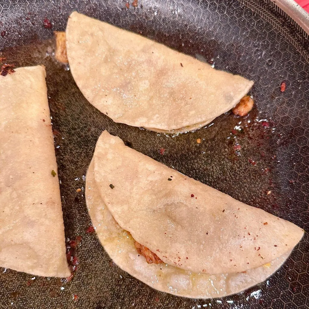Frying Chicken tacos in a large skillet.