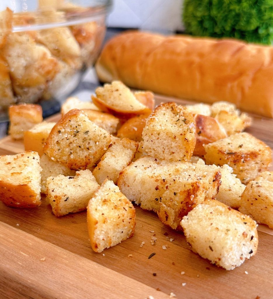 Easy Homemade Croutons on a wooden cutting board with a loaf of bread.