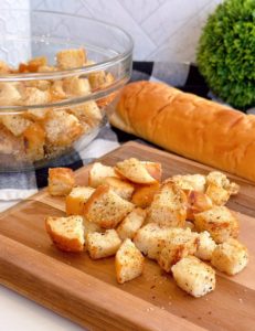 Easy Homemade Skillet Croutons on a cutting board with a bowl full in the background.