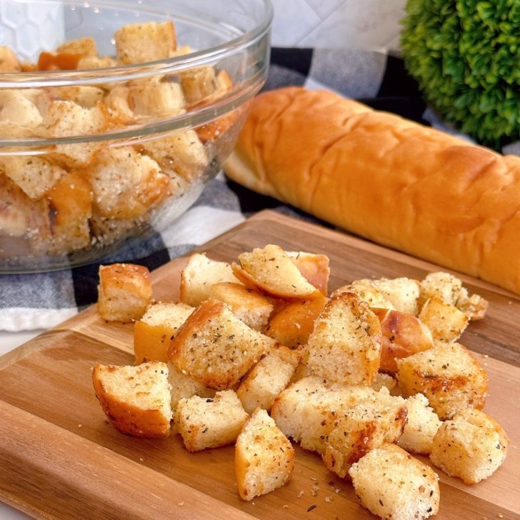 Easy Homemade Skillet Croutons on a cutting board with a bowl full in the background.