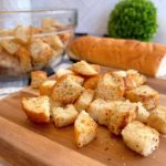 Homemade Skillet Croutons in a bowel and on a cutting board.