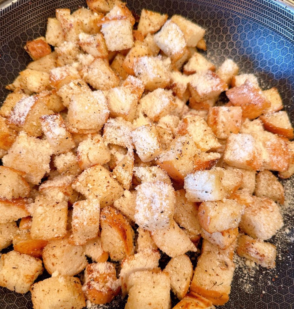 Croutons in the skillet toasted a golden brown with Parmesan Cheese. 