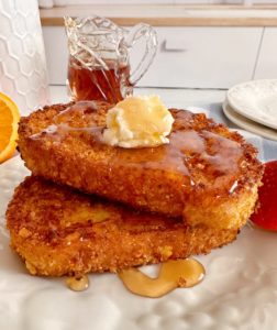 Cereal Coated French Toast stacked with butter and maple syrup.