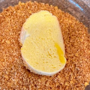 Bread being dipped in the cornflake coating.