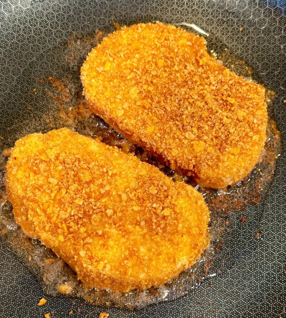 Slices of French toast in a large skillet on the stove.