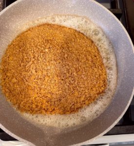 Cornflakes and cinnamon in melted butter in the skillet over medium heat.
