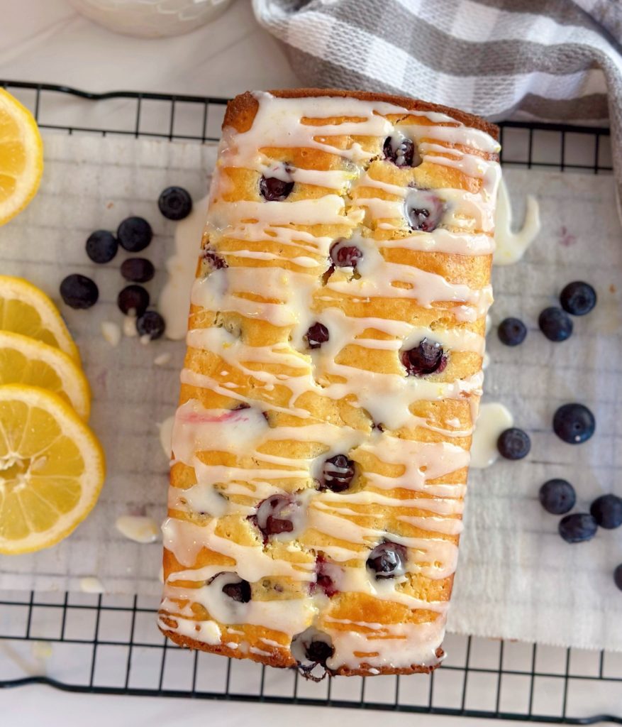 Overhead shot of Lemon Blueberry Bread on a cooling rack with lemon glaze dripping down the sides.