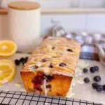 Freshly glazed Lemon Blueberry Bread on cooling rack.