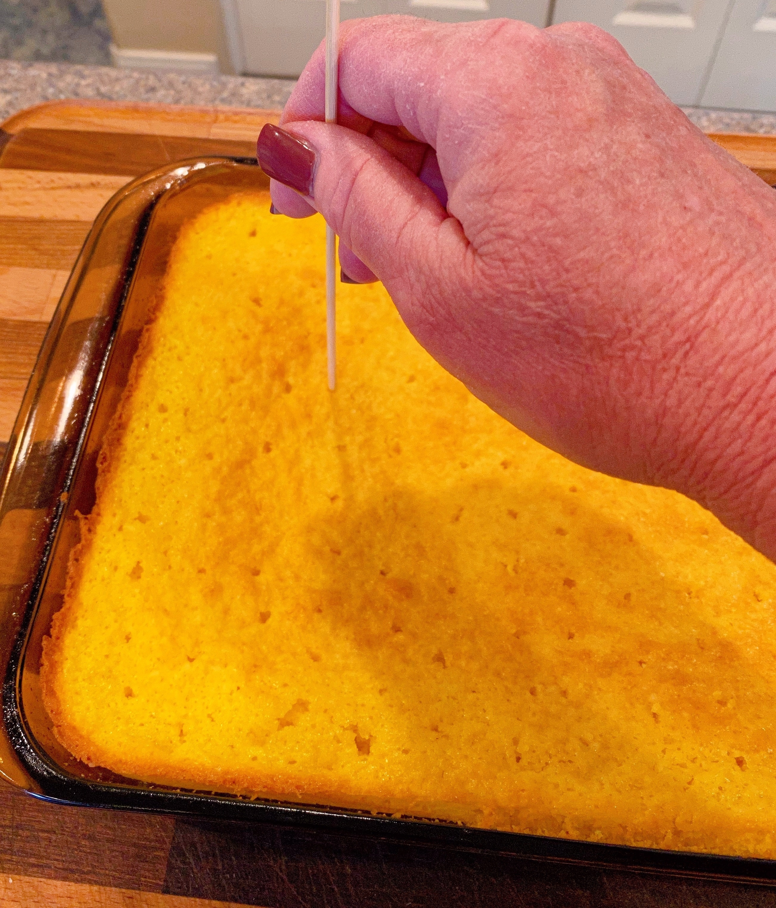 Poking holes in lemon cake with bamboo skewer. 