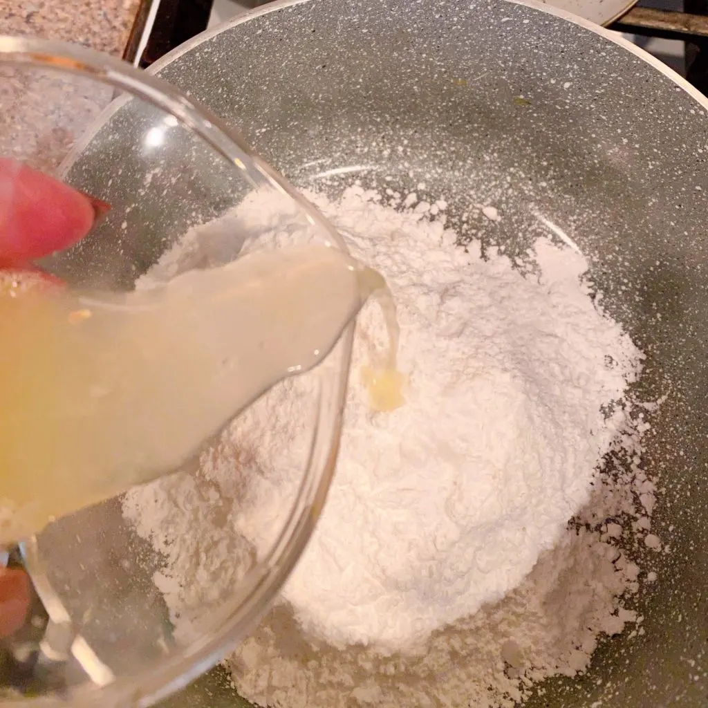 Powder sugar with lemon juice in sauce pan over medium-high heat.