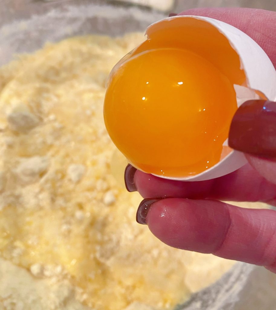Adding wet ingredients to the cake mix, including eggs.