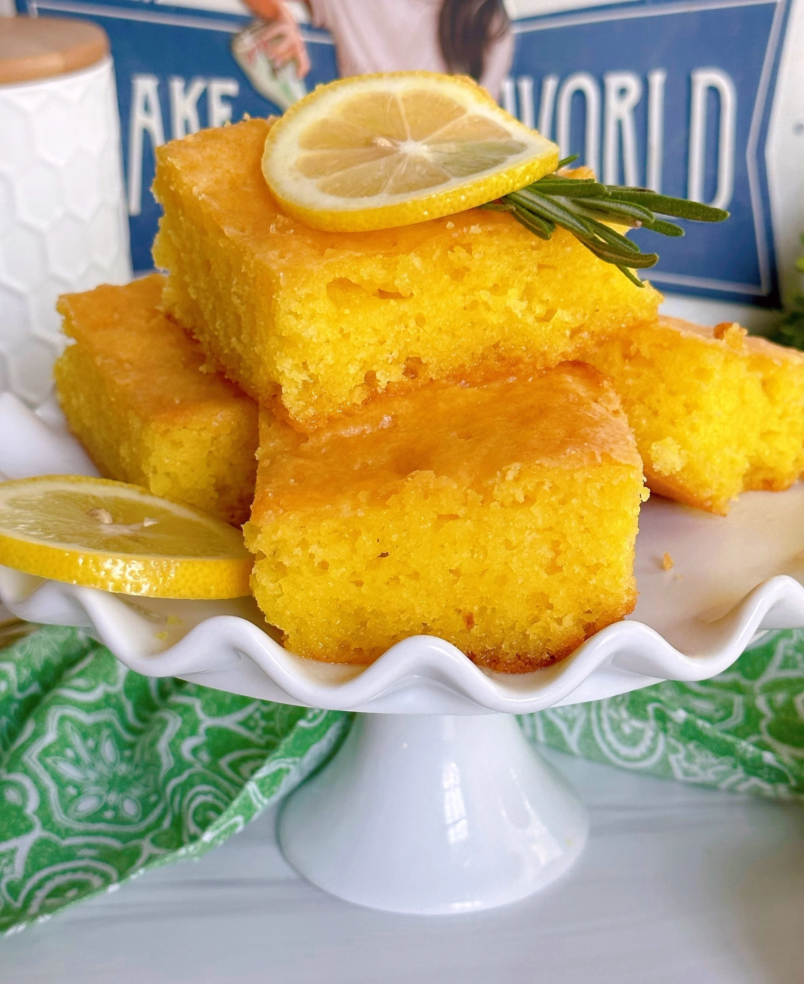 Lemon cake slices on a cake stand with lemon slices.