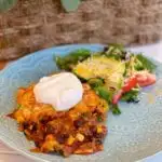 Cornbread Taco Chili Casserole Serving on blue plate with salad.