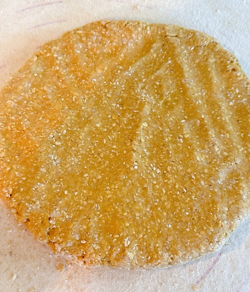 Dough formed into a large disc about 1 inch thick.