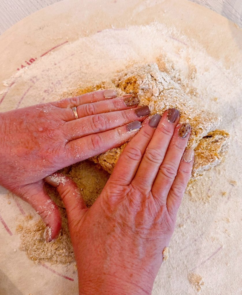 Gently kneading scone dough into a disc.