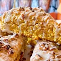 Oatmeal Pumpkin Scones with Maple Glaze with pecans stacked high.
