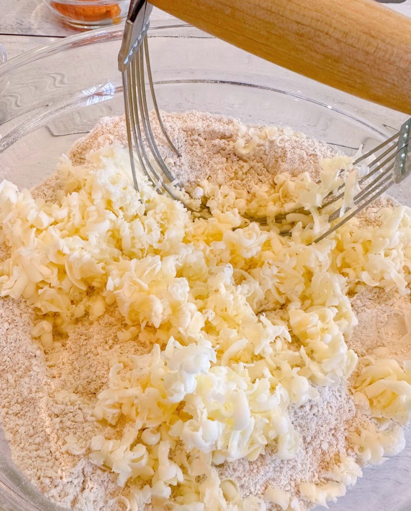 Adding cold butter to dry ingredients.
