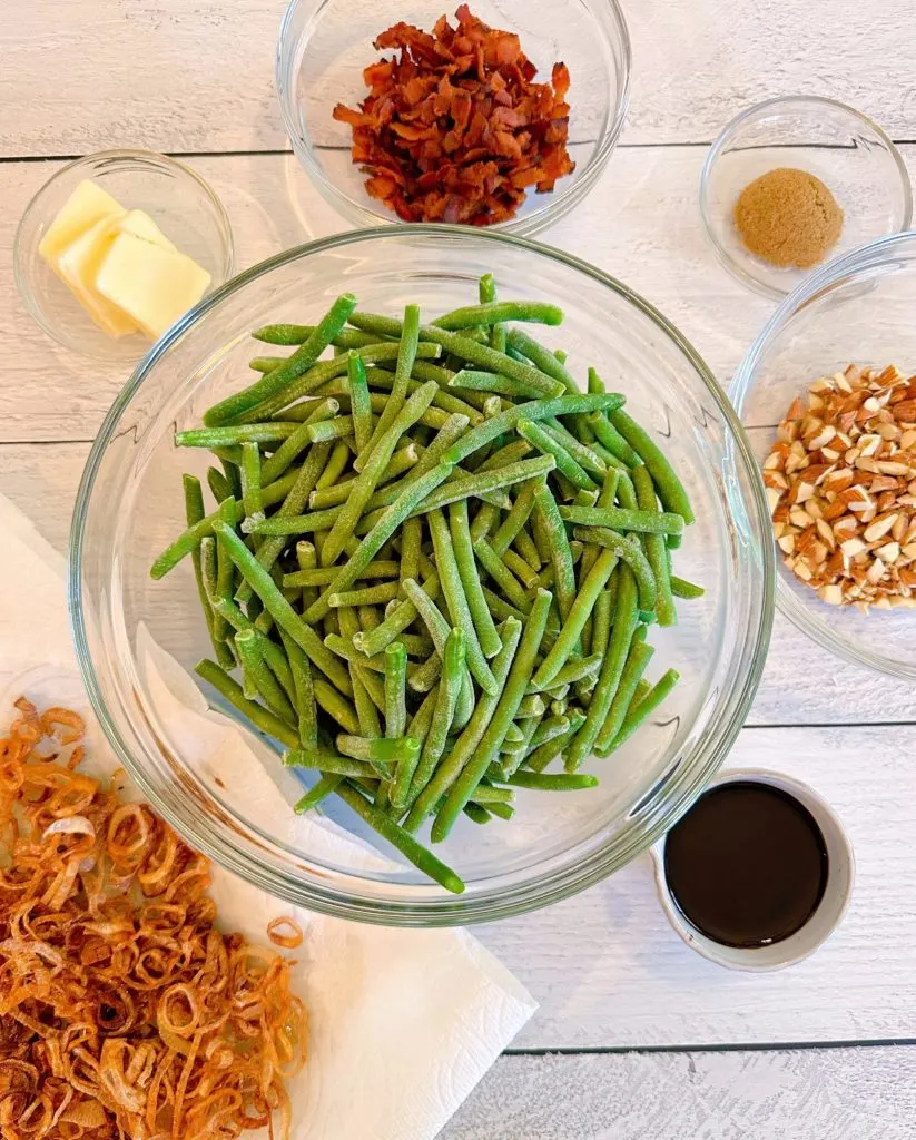 Ingredients of a white wooden board for Balsamic Green Beans.