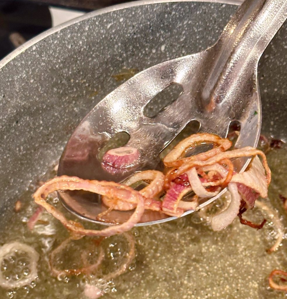 Frying shallots in large sauce pan and removing fried shallots with slotted spoon.