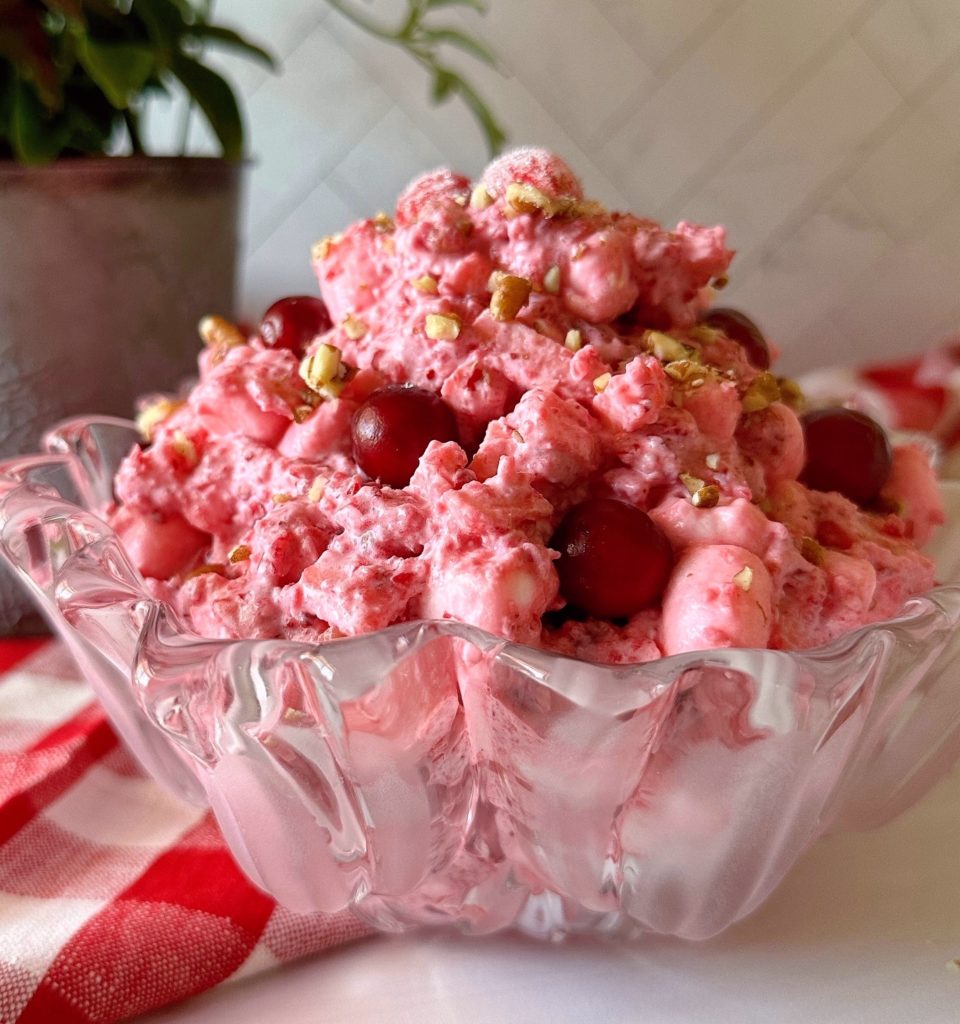 Cranberry Apple Fluff Salad in a glass bowl sprinkled with fresh cranberries.