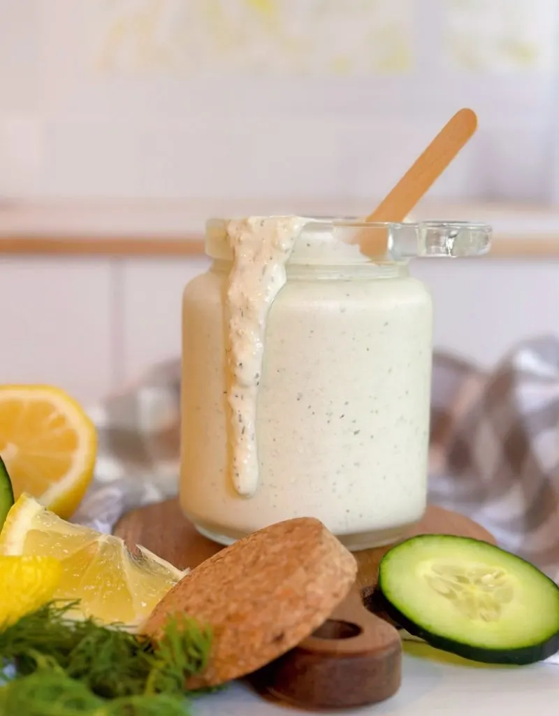 Dill Sauce in a glass jar surrounded by ingredients.