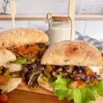 Greek Portobello Veggie Sandwiches on a wooden cutting board.