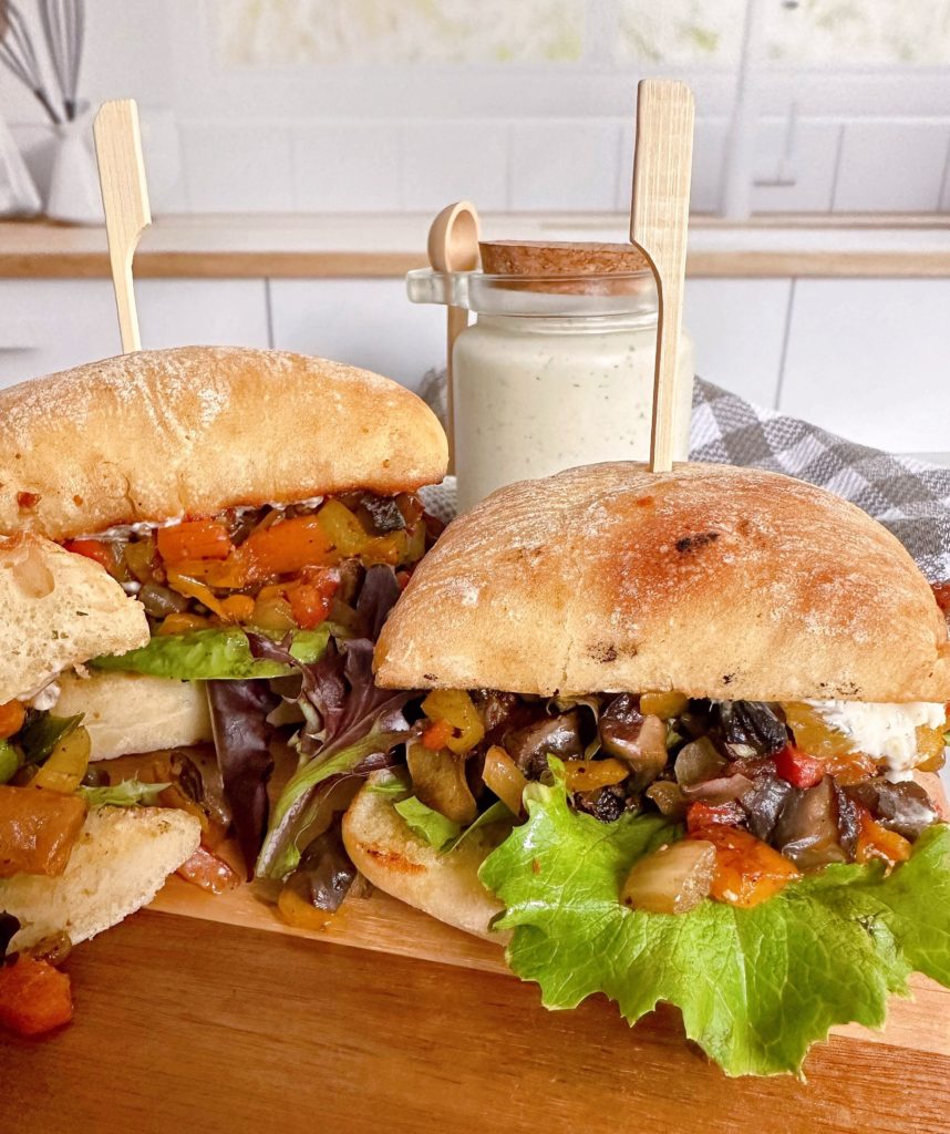 Greek Portobello Veggie Sandwiches on a wooden cutting board.