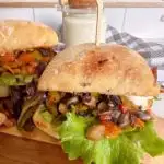 Greek Portobello Sandwiches with Dill Sauce in the background on a cutting board.