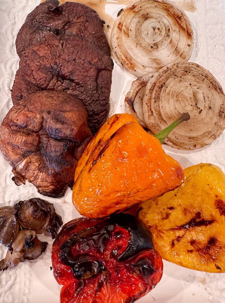 Grilled Vegetables on a table waiting to be chopped.