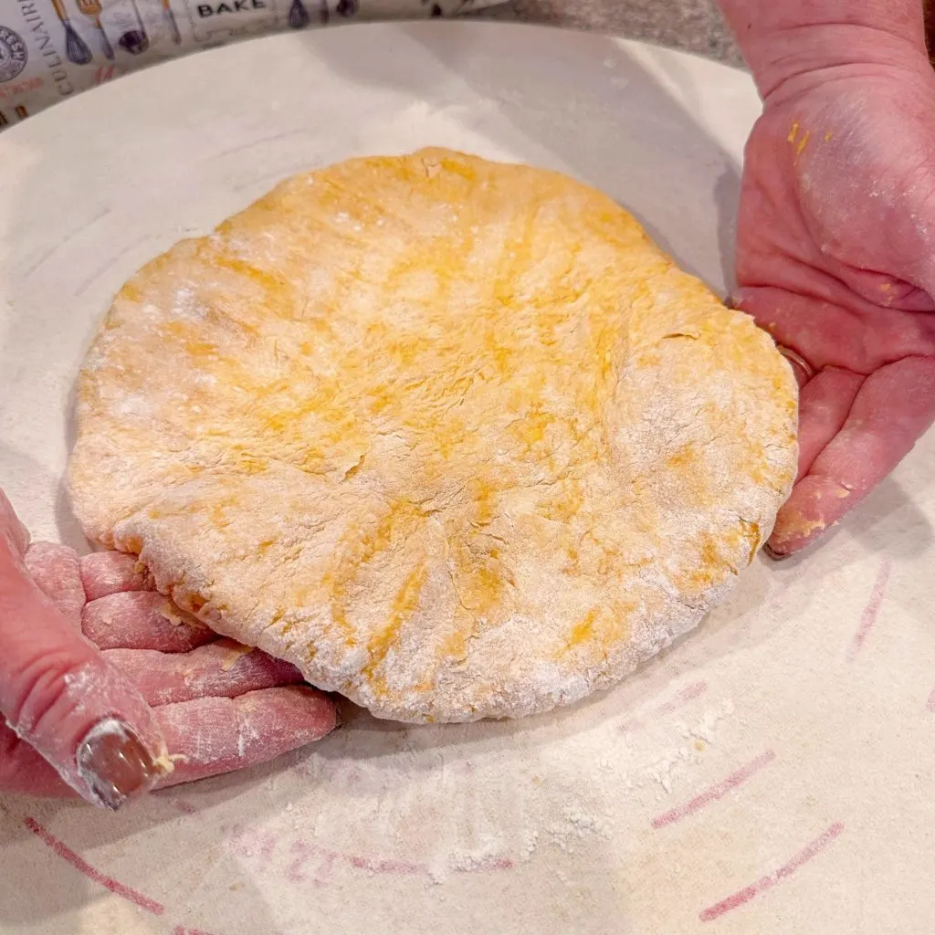 Dough patted into a rectangle on a floured surface.