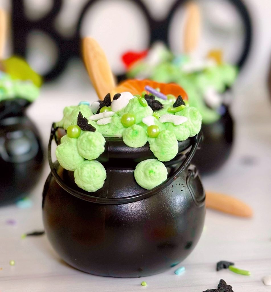 Black Cauldron Dessert Cups close-up with sprinkles and gummy worms.