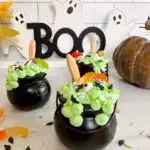 Halloween Witches Pudding cups with wooden spoons and candy bug sprinkles.
