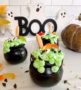 Halloween Witches Pudding cups with wooden spoons and candy bug sprinkles.